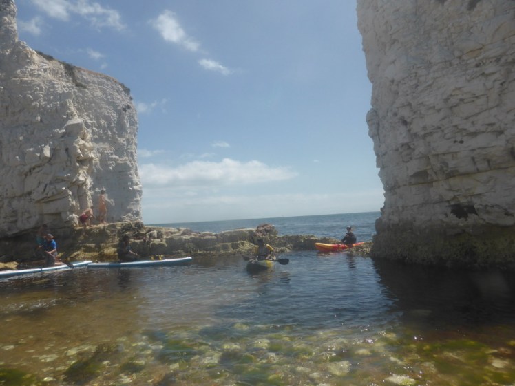 Kayakers coming through the gap in Old Harry Rocks