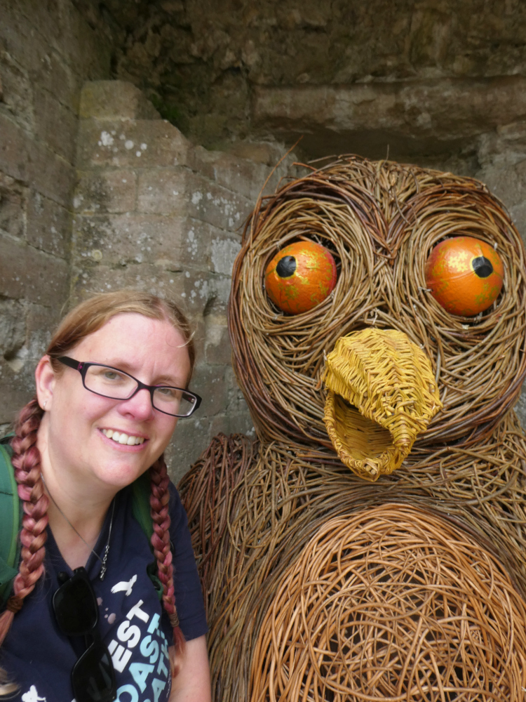 A selfie with a huge wicker owl on the way back to the car. I'm a bit sweaty, with my hair in two plaits and wearing a South West Coast Path t-shirt.