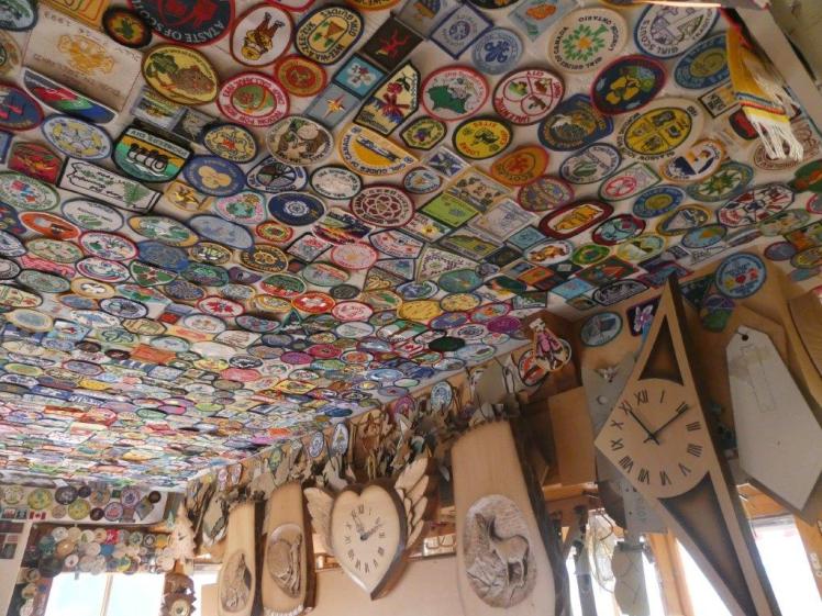 The woodcarver's ceiling, covered in patches from Guides & Scouts from around the world