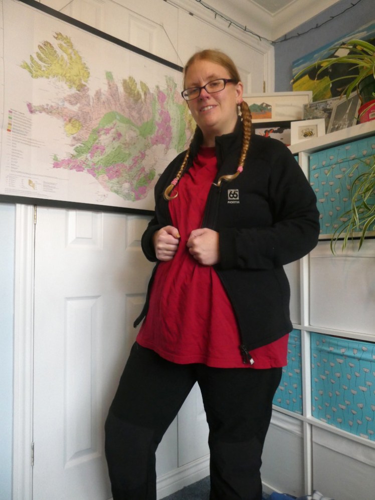 Now I'm wearing a large red t-shirt. Over it is another black jacket, this one open, although I'm holding it by the zip. It's very simple, with no pockets or hoods or weird insert.