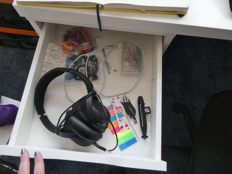 Contents of my top desk drawer: coloured ink cartridges, mini pegs, allen keys from construction, noise-cancelling headphones, two USB sticks and a pack of sticky tab flags.