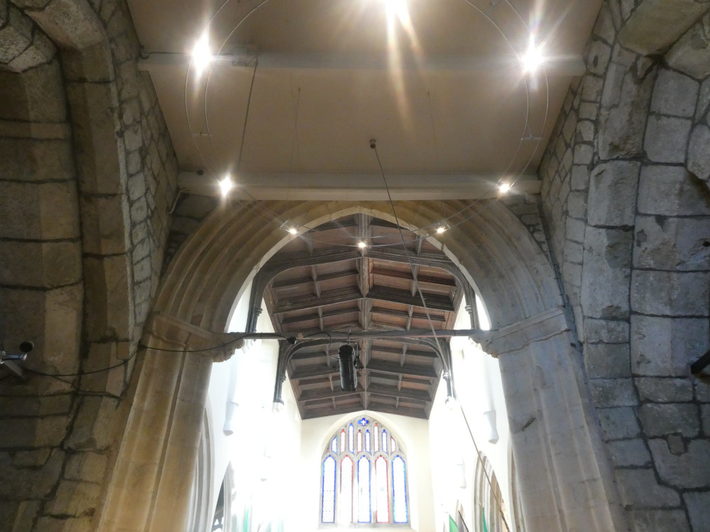 Three ancient stone arches meeting in three sides of a square but ruined with an ugly ceiling that cuts off the top of the forward arch.
