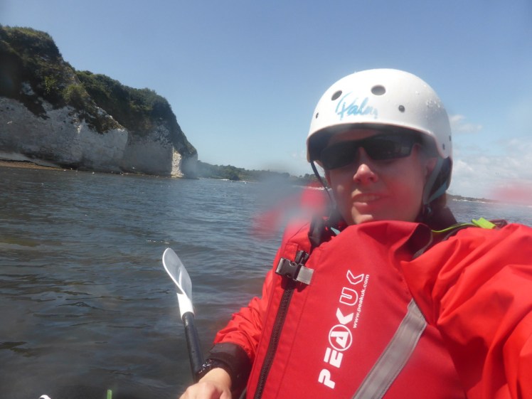 Kayaking off Studland. I'm wearing a red waterproof and buoyancy aid and a white helmet