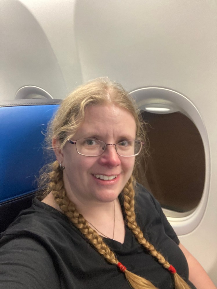 A selfie sitting on the plane on my way from Amsterdam to London. Despite having done my hair, that was now some twelve hours ago and I look dishevelled again.