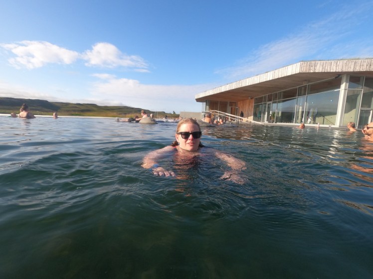 Me swimming in the bar pool at Vok Baths, under a blue sky.