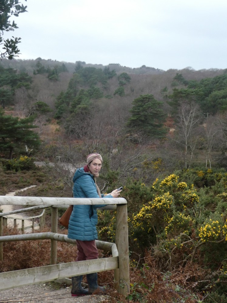 Catherine, learning on a wooden fence, to look out over the nature reserve. She's just turning back towards me and I've caught a fleeting disapproving expression that was probably there and gone so quickly I wouldn't have seen it with my eyes.