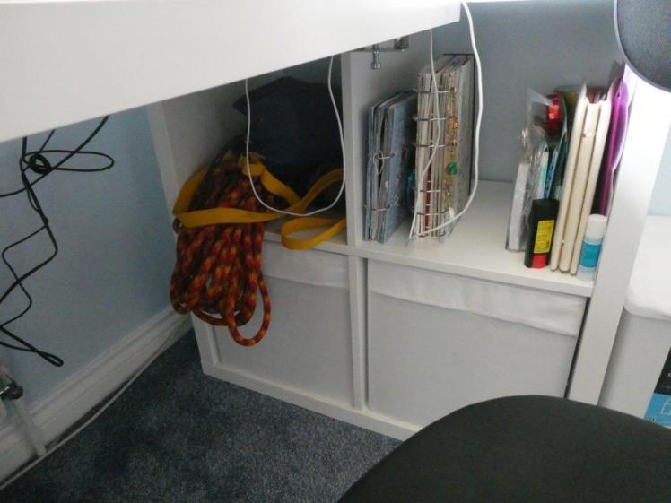 Contents of the Kallax below desk-level. Clockwise from top left: my caving SRT kit and rope, assorted scrapbook stuff, a box of musical instruments and a box of jumpers