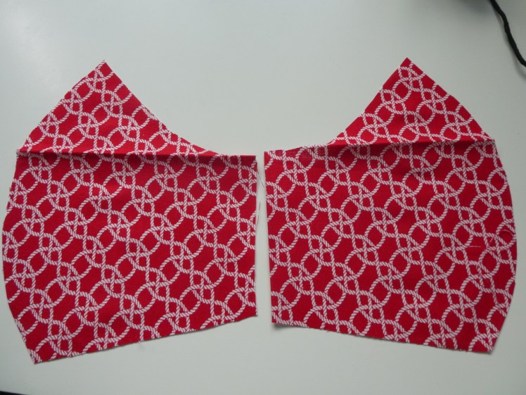 The two pieces that will form one side of a duck-bill face covering, mirrors of each other