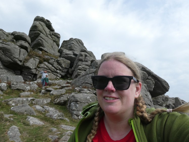 Me sitting directly below Hound Tor, wearing a green fleece and a red technical t-shirt and looking a touch wind-burned.