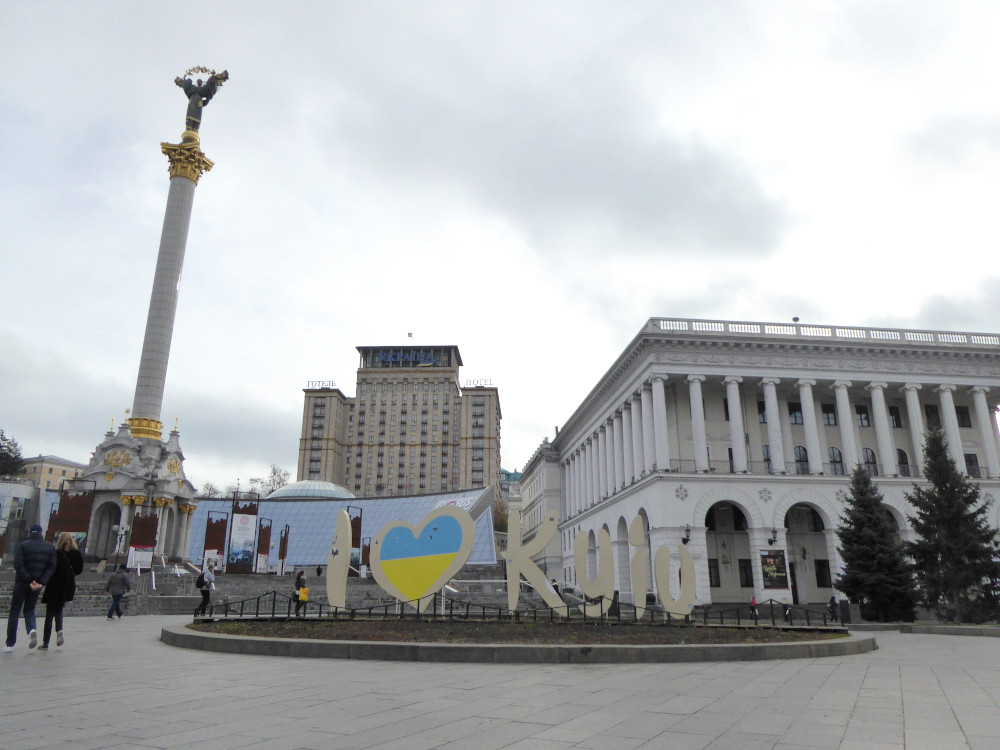 The same square but seen from a viewpoint further to the right. There is a large sculpture of the words I HEART KYIV. The heart is filled in with the blue and yellow of the Ukrainian flag.