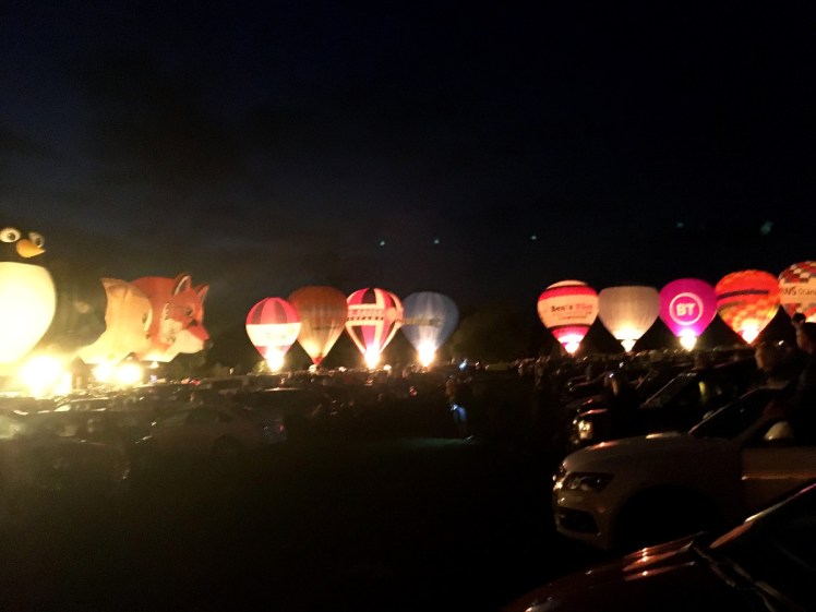 Hot air balloons lit up in the dark