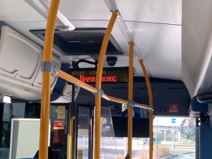 An LED sign hanging from the ceiling of the bus saying "next stop, Hamraborg".