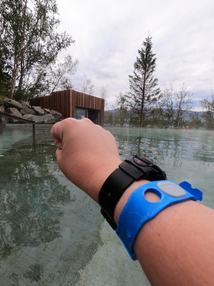 My wrist, with my black watch on and a slightly battered bright blue plastic bracelet.