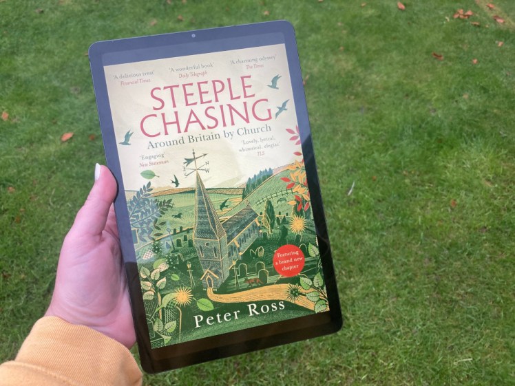 The cover of Steeple Chasing by Peter Ross on my tablet. It has a largely green and yellow woodcut scene of hills and trees and a big church in the middle.