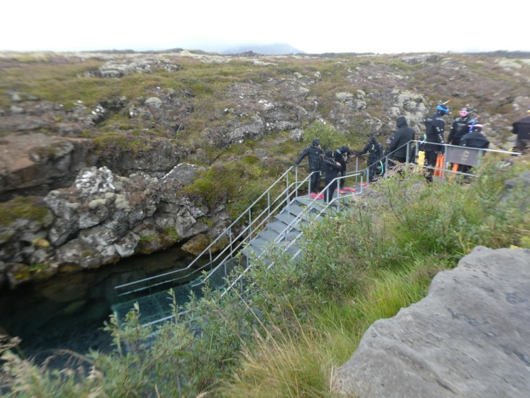 Divers in drysuits at the top of the stairs down into the fissure. They're all wearing drysuits, it's a very grey, cold-looking day, you can't see but the wind is howling and it is August 20th.