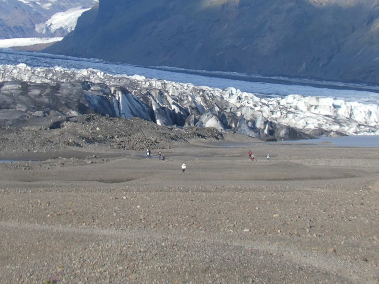 The tongue of a glacier, fading out as it reaches its own terminal moraine. Look closely and you'll see people like little dots in front of it, giving you an idea of how big the glacier is, even right down here.