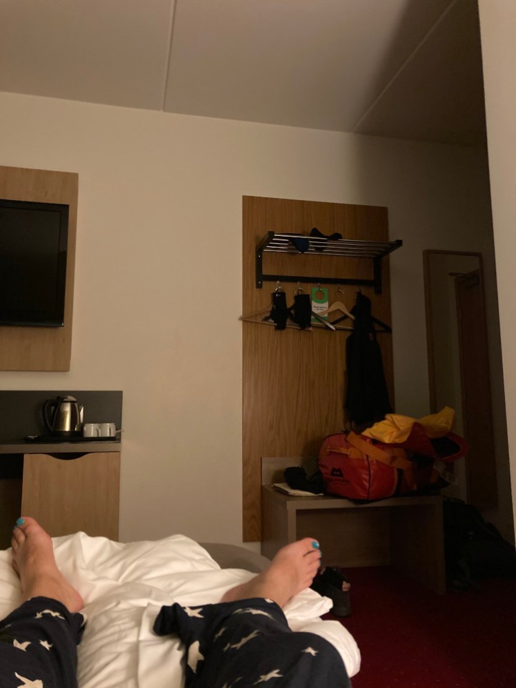 My feet, as I lie back on a bed in a slightly darkened hotel room. It's a nice enough hotel room but absolutely not worth what I paid for it.