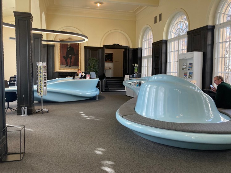 Inside tourist information. The room itself is a Neo-Renaissance wood-panelled room with massive windows but the desks are light blue curves that look straight out of 1960s scifi.