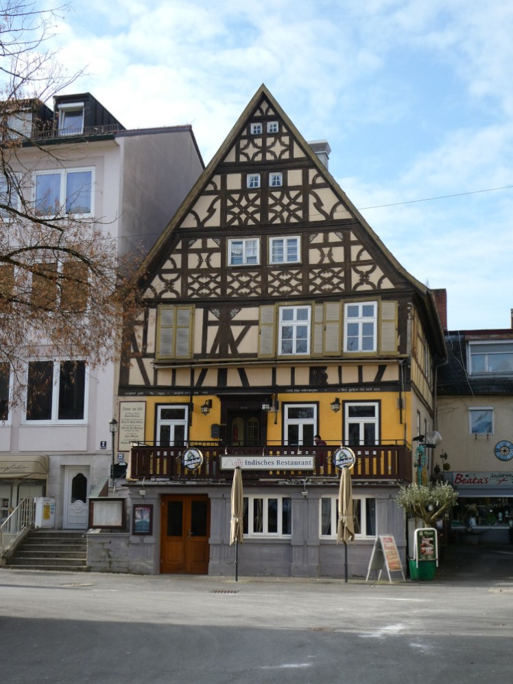 A yellow pub with a pointed roof and dark wood criss-crossing over the front. It looks like something lifted straight out of the Brothers Grimm.