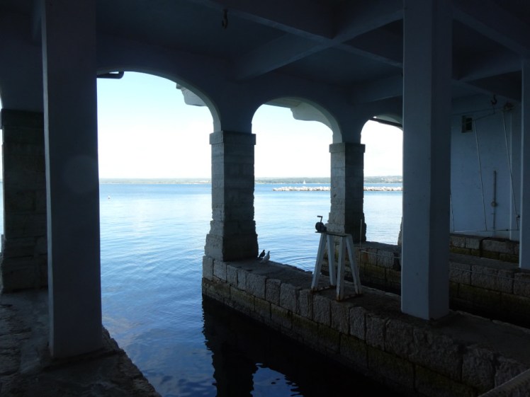 Inside the boathouse, in the ornate bays that open directly onto Brijuni's harbour. Inside the boathouse it's quite dark but the sea outside glows bright blue in the sunshine.