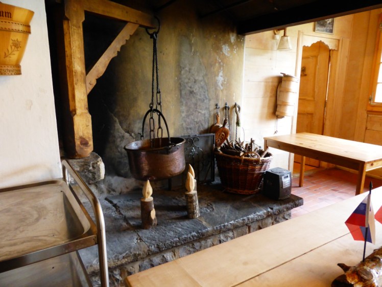 A massive and obviously-used open fireplace, with wooden candles carved from actual branches and a big copper cauldron hanging from a wooden arm over where the fire would be.