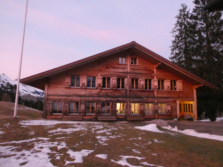 The main chalet at sunset in the snow during the New Year Break 2019-2020. The entire photo is tinted pink by the spectacular sky.