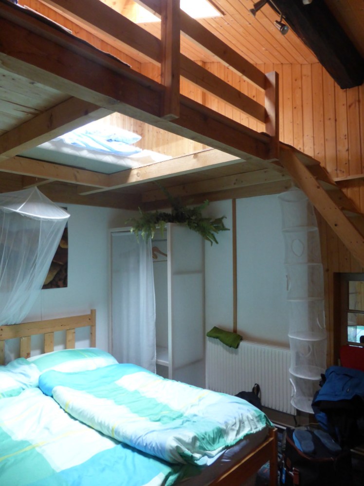 A room for four - an Austrian double (two single mattresses and duvets on a double base) under a wooden half-upstairs with two mattresses laid over the glass floor. Great room for parents and kids; not so much for four unrelated adults.