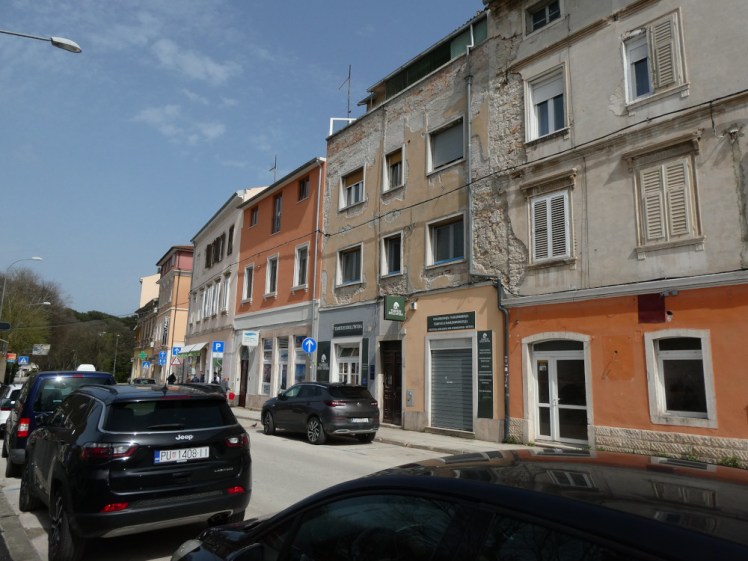 The outside of my apartment building in Pula. It's one of a terrace of houses, most of them with plaster peeling off to reveal brick underneath. Mine is the one in the middle, yellowish at the bottom, between the one that's orange at the top and the one that's orange at the bottom.