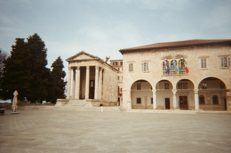The Forum, a square in Pula that's been there since Roman times, as evidenced by the surviving Roman temple in the corner. The medieval City Hall next to it used to be two more temples. The film photo makes both buildings glow a soft golden colour and there's only one person captured in a square that's usually very busy.