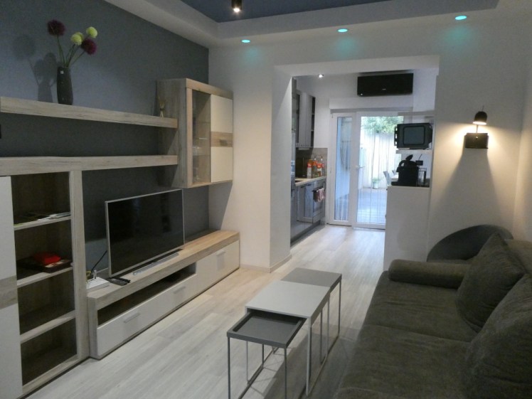 The grey-blue living room. Now you can see the sofa opposite the TV, as well as the blue-grey ceiling and wall.