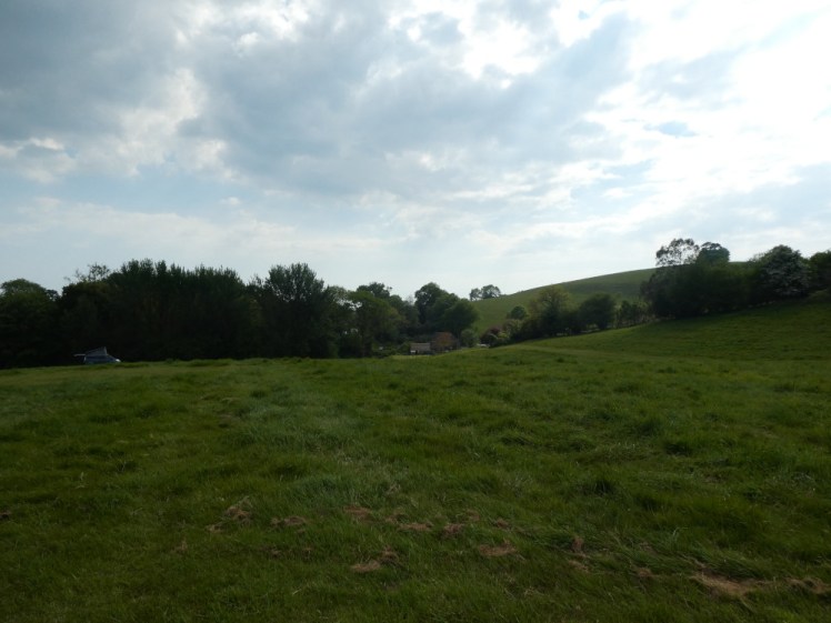 Looking down the campsite towards the farmyard. It's a field that runs flat and then slopes down quite swiftly. You can see a van parked at the far end of the field - it is on pitch 4.