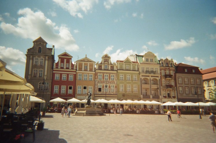 The main square in Poznan - one side of a square made up of tall, thin colourful houses.