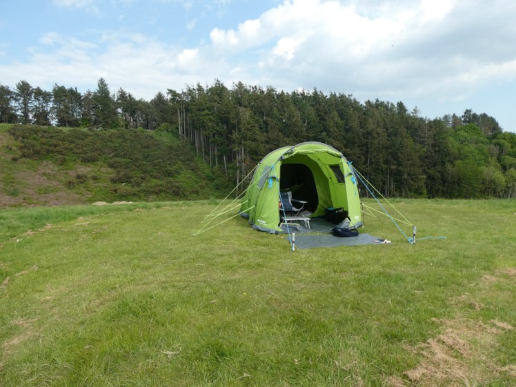The tent pitched on my own little pitch. You can see behind that the ridge drops away and immediately rises up again and the hill behind is covered in trees. The tent itself looks fine from this angle, its missing pole at the back not visible from here.