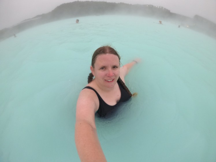A selfie taken from above in the Blue Lagoon. The water is an opaque whiteish blue-green and it's very misty.