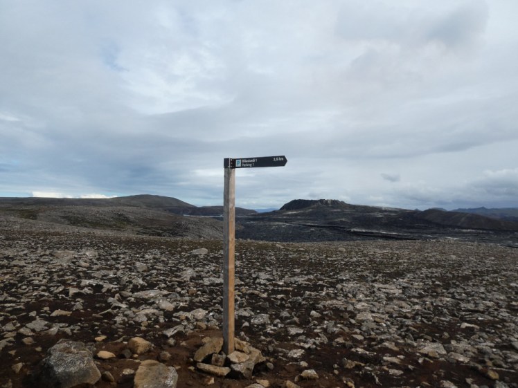 The "path" out to Meradalir in 2022. A wooden signpost stands in a field of rough stones which doesn't at all look (or feel!) like a path.