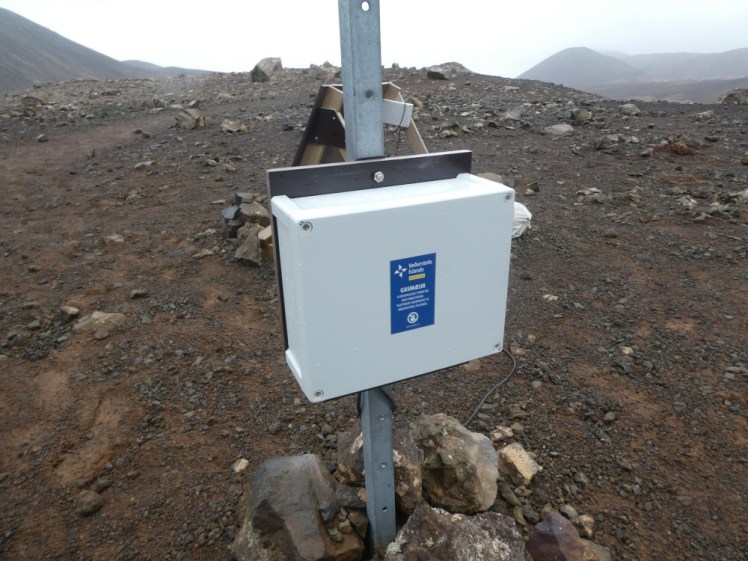 A gas meter mounted on a pole just beyond the lava at Fagradalsfjall.