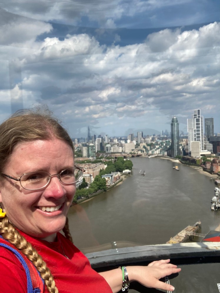 Me, wearing a red t-shirt, with the view from Lift 109 over central London, from the top of the chimney at Battersea Power Station.