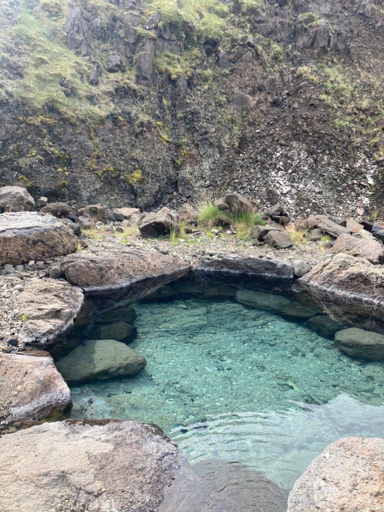 The lower pool, Urður, which is a roundish pool, quite shallow, filled with pale blueish translucent water and a few rocks in the water to act as steps and seats.