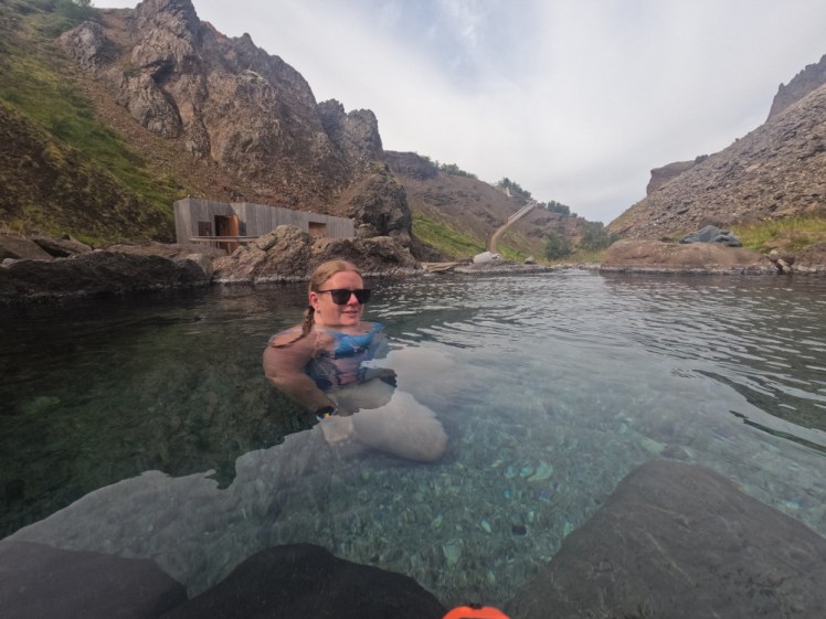 A selfie taken by balancing the GoPro on the edge of Urður. I'm sitting very awkwardly with the canyon walls and the changing cabin behind me.