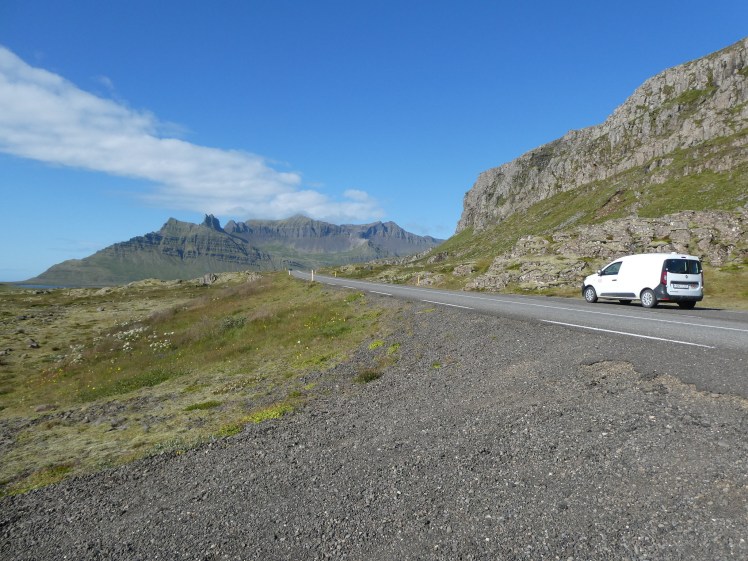 My campervan, a small white panel van meant for two people, parked on the side of a mountain road.