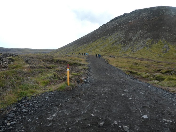 The start of the path that was built for Fagradalsfjall, extended for Meradalir and is now being used for Sundhnúkagígar. It's a black gravelly path leading through mossy meadows, past a big rounded hump of a hill.