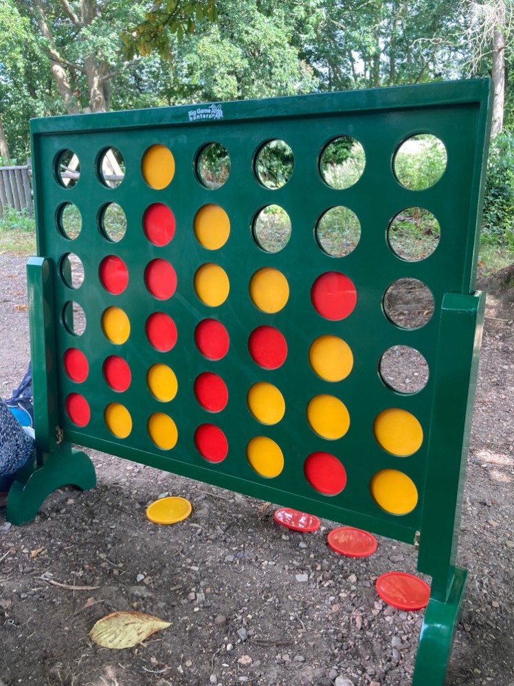A giant Connect 4 board where red has connected 3 several times and yellow was excited to get 4 in a row, only to discover it was already 4 in a diagonal line and now it's 5 and no one noticed.