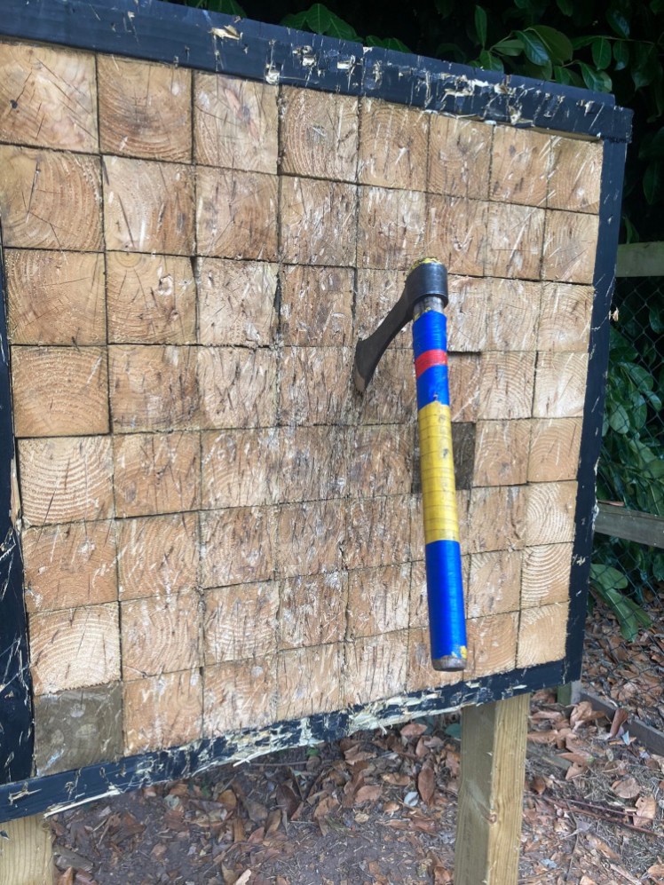 A large axe with a tape-covered handle stuck right in the middle of the target, which is made up of 8x8 square wooden blocks.