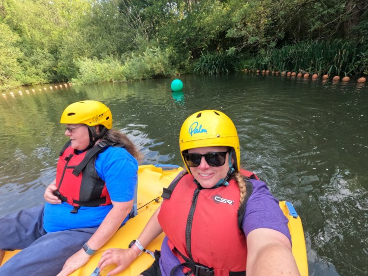 Me and Charlotte, wearing faded red buoyancy aids on a yellow pedal boat on the lake.