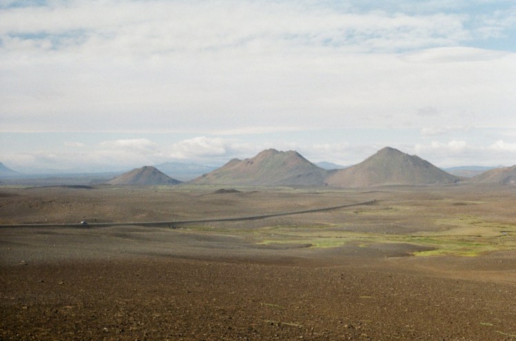 A ridge of mountains across the Desert of Misdeeds, a vast barren brown lava field.