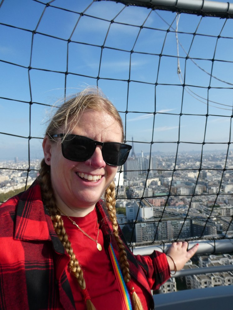 A selfie in a red t-shirt and a red and black checked shirt, in a balloon 150m above Paris.