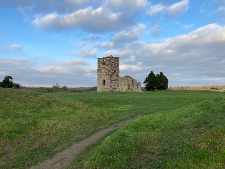 Knowlton Church as seen from the western entrance to the henge where a worn footpath makes its way between the two sides of the ramparts rising up.