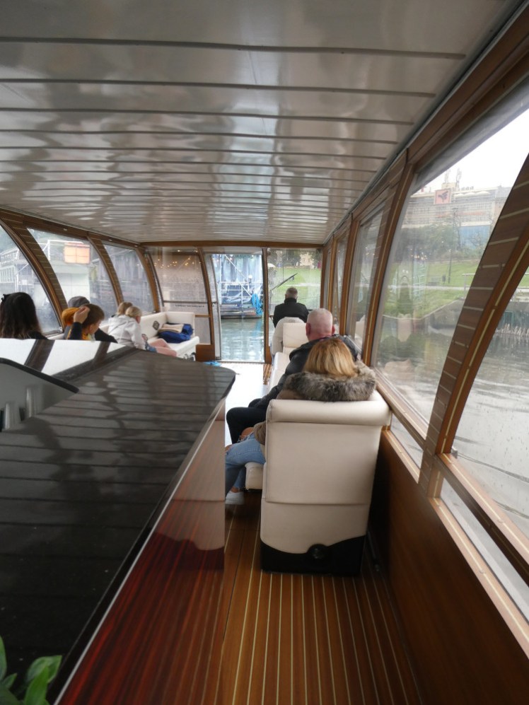 Inside our tour boat, a kind of lounge with white leather seats running each length of the glass-sided boat, facing inwards.