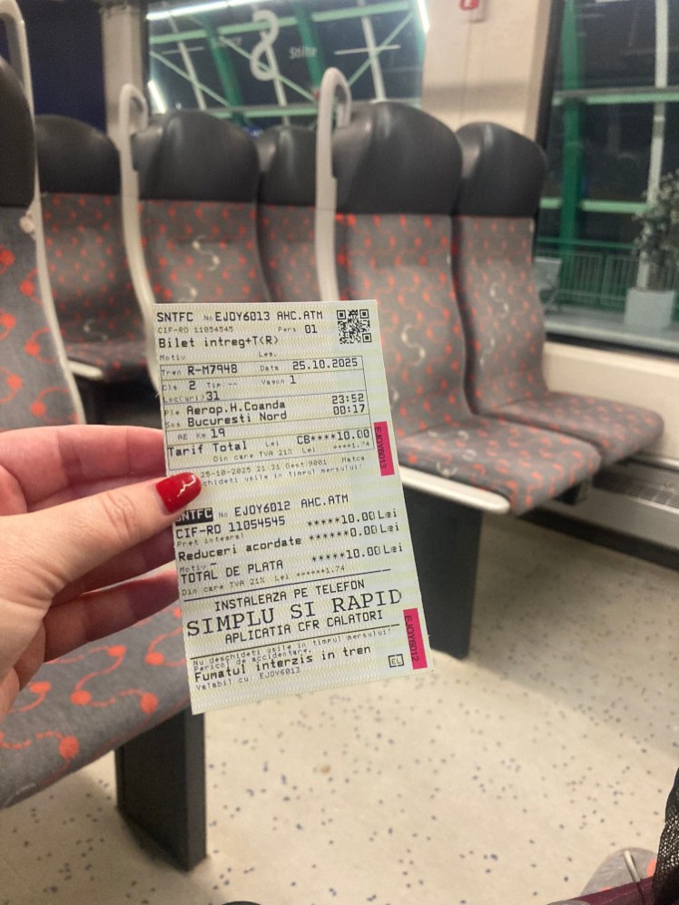 A paper train ticket held up on the train. It's not actually for this train, so I had to buy a  replacement ticket from the conductor.