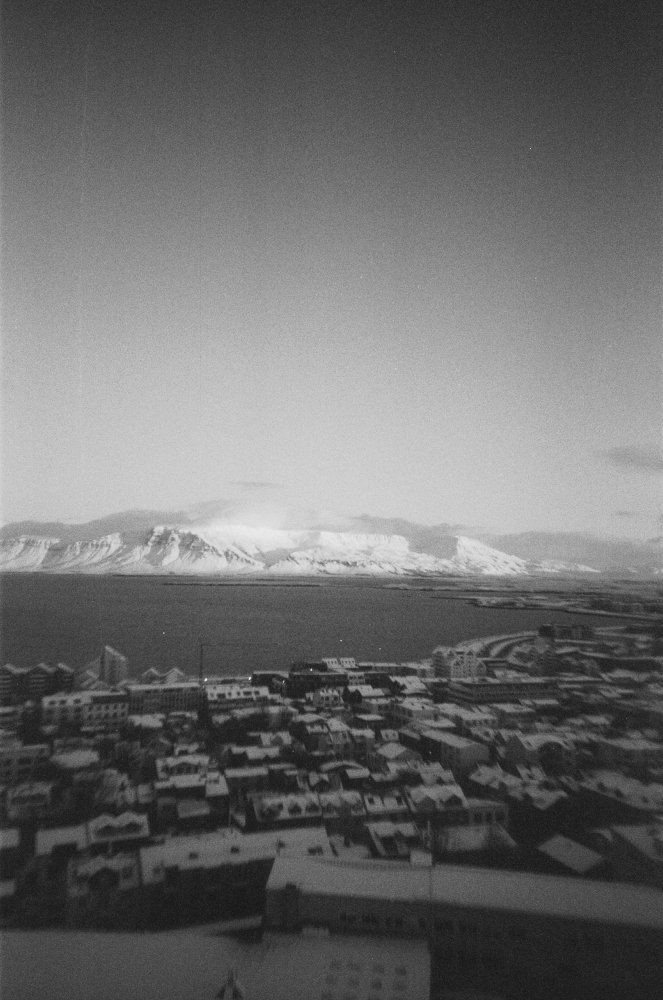 A view of Esja, the snow on top of the mountain glinting in the winter sun, behind Reykjavik spread out below and the bay.